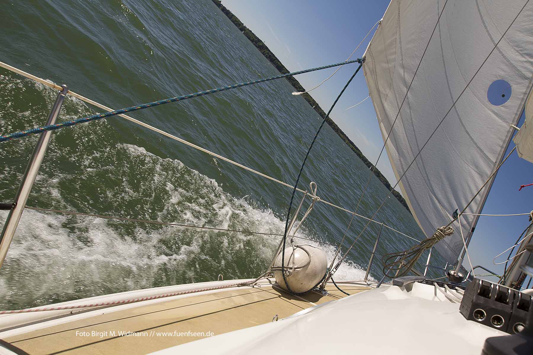 fuenfseen Segelboot in Fahrt auf dem Chiemsee mit spritzendem Wasser Chiemgau Bayern