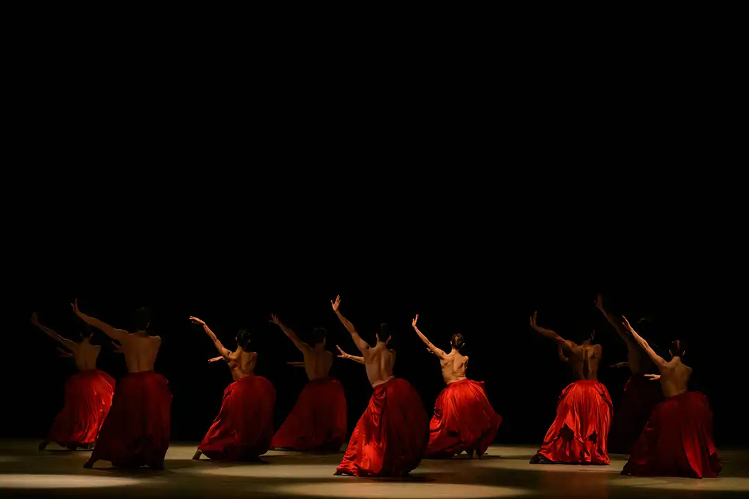 dunkle Bühne mit neuen BalletttänzerInnen in knallroten Reifröcken. Premiere der Ballettfestwoche München Bella Figura
