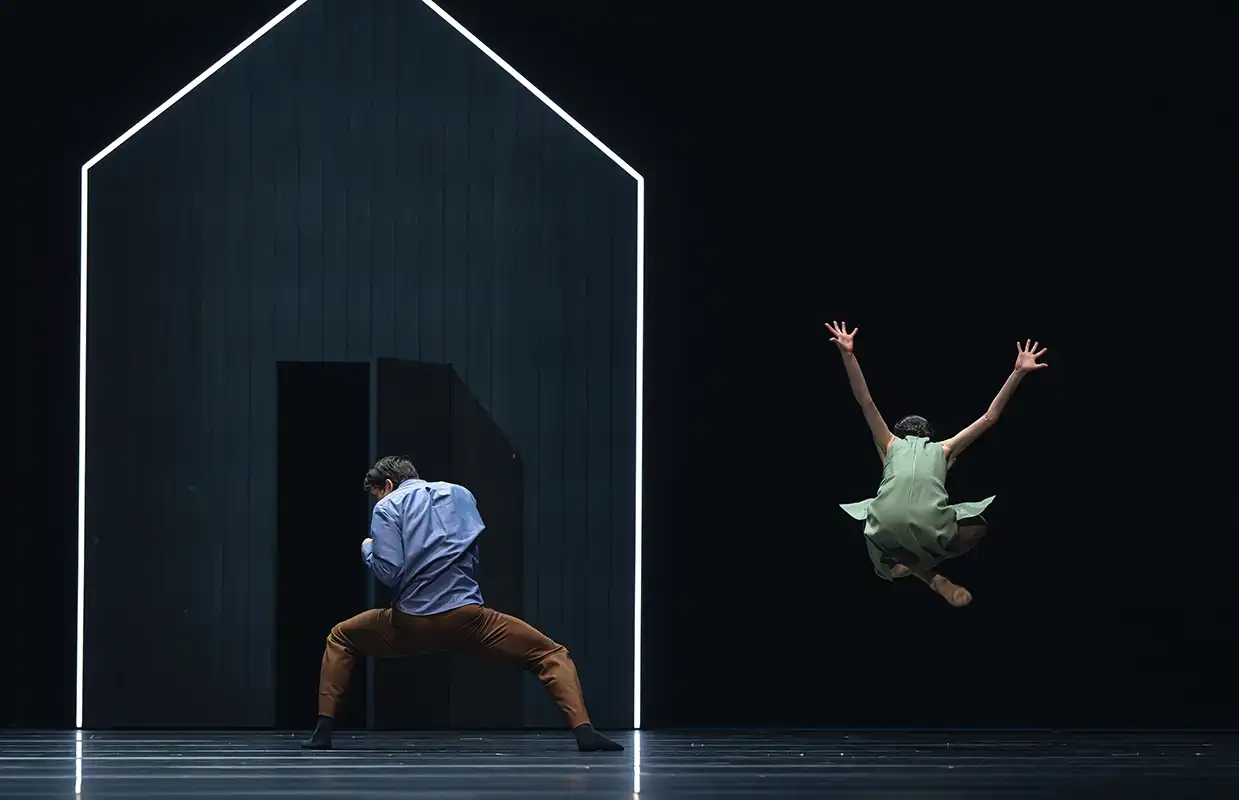 Szene Impassi Common Ground Nationaltheater Ballettfestwochen Premiere leuchtendes Haus im dunklen mit zwei Tänzern